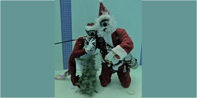 Santa and Mrs. Claus under water in a swimming pool